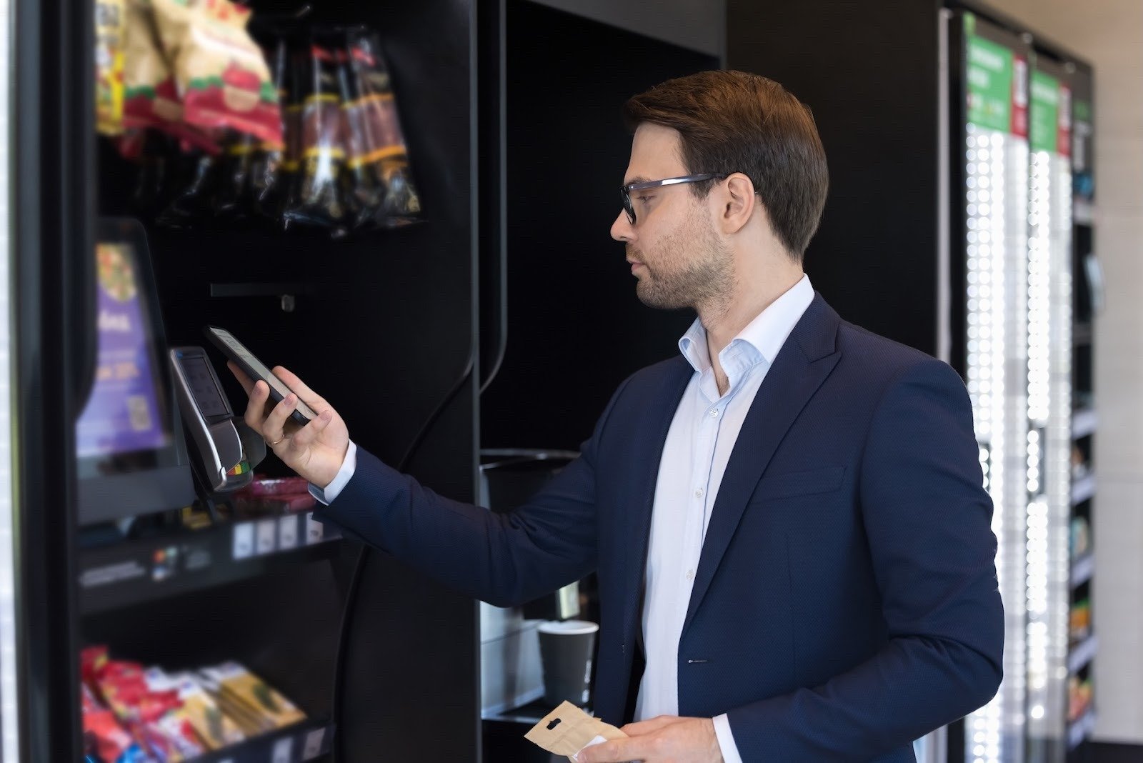 Man using tap-to-pay with his phone at a vending machine